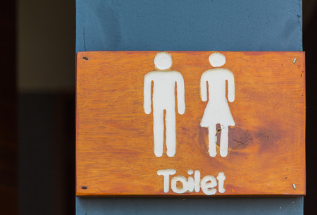Wooden sign hung over the entrance to a toiletの写真素材