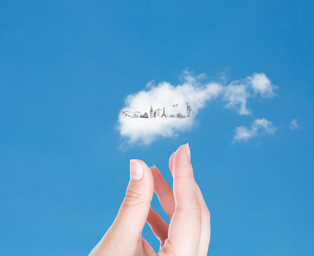 Hand with cloud of travel  in blue sky   (Japan,France,Italy,New York,India,egypt)の写真素材