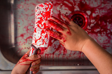 Hand hold bloody knife in a steel shell for halloweenの写真素材