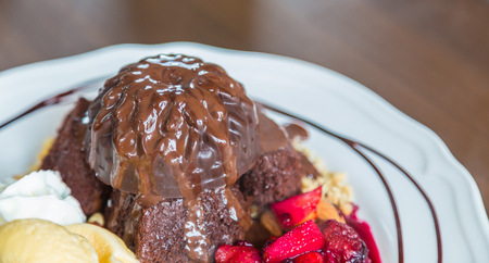 Chocolate cake with fruit peach, black currant, blueberry, apple, ice creamの写真素材