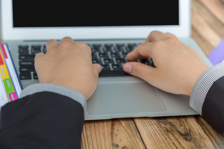 Closeup of business woman hand typing on laptop keyboardの写真素材