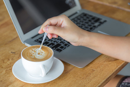 Closeup of business woman hand mix coffeeの写真素材