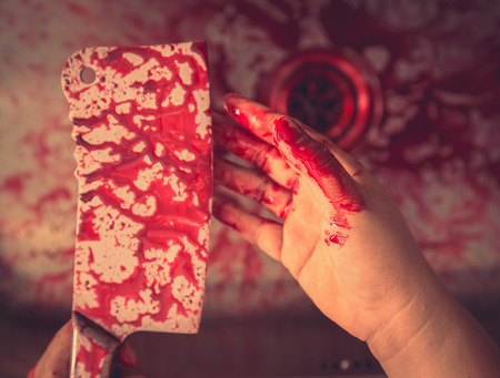 Hand hold bloody knife in a steel shell for halloween ( Filtered image processed vintage effect. )の写真素材