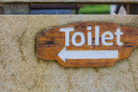 Wooden sign hung over the entrance to a toiletの写真素材