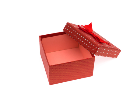Red gift box with red and glod ribbon on white backgroundの写真素材