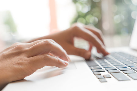 Closeup of business woman hand typing on laptop keyboard