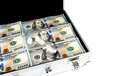 Suitcase of money with hundred dollar and light bulb for idea on white  background