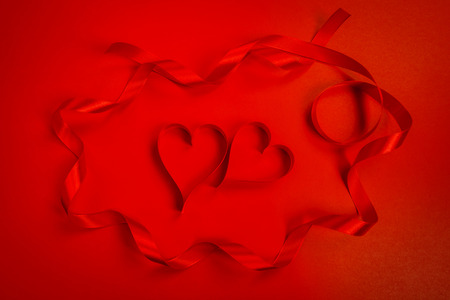Red ribbon hearts on red background For Valentines dayの写真素材