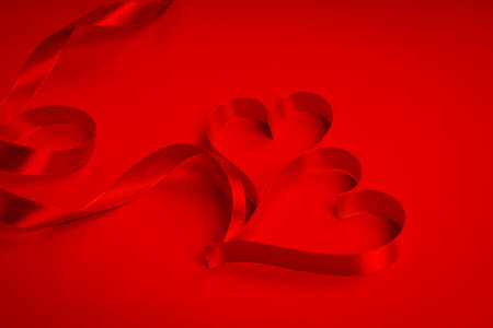 Red ribbon hearts on red background For Valentines dayの写真素材