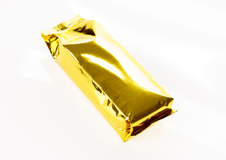 Golden foil bag package on white backgroundの写真素材