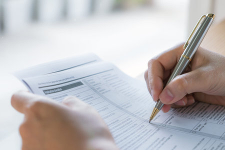 Hand with pen over application form