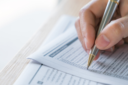 Hand with pen over application formの写真素材