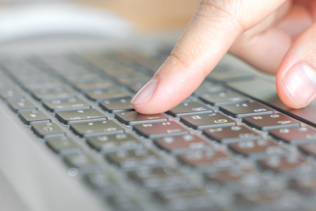 Closeup of business woman hand typing on laptop keyboard