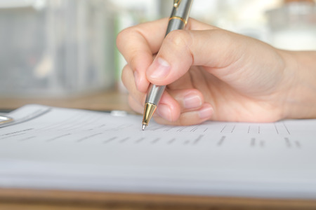 Hand with pen over application formの写真素材