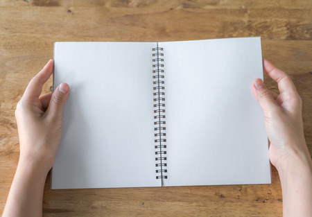 Hands open Blank catalog, magazines,book mock up on wood tableの写真素材