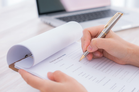 Hand with pen over application formの写真素材