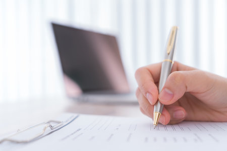 Hand with pen over application form