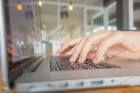 Closeup of business woman hand typing on laptop keyboard
