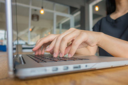 Closeup of business woman hand typing on laptop keyboard
