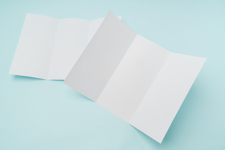 Trifold white template paper on blue backgroundの写真素材