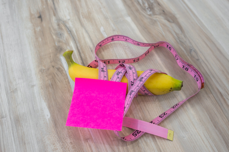 Banana with Sticky Note on wood tableの写真素材