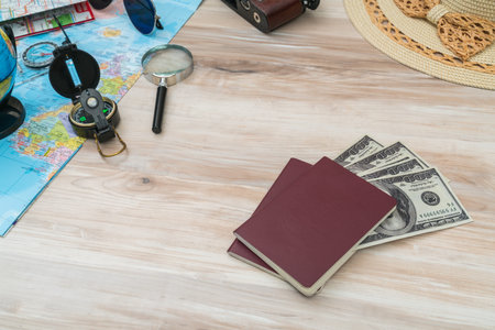 Travel preparation : compass, money, passport, road map ,hat,sunglasses,magnifying glass on wooden tableの写真素材