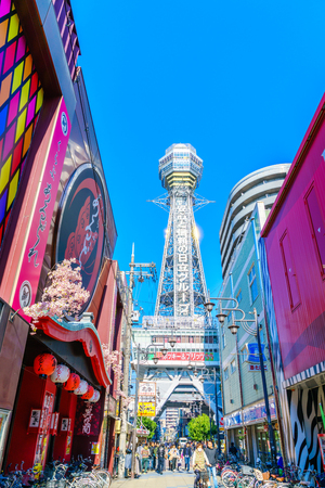 OSAKA, JAPAN - NOVEMBER 30, 2015: Tsutenkaku Tower in Shinsekai (new world) district with blue sky. It is a tower and well-known landmark of Osaka, Japan and advertises Hitachi.のeditorial素材