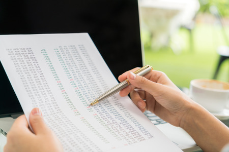 Business woman hand with Financial charts and laptop on the tableの写真素材