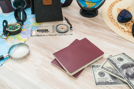 Travel preparation : compass, money, passport, road map ,hat,sunglasses,magnifying glass on wooden tableの写真素材