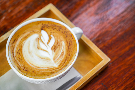 Latte Coffee art on the wooden tableの写真素材