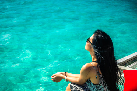 Portrait of happy young woman at beautiful water villa at Maldives island. Travel and Vacation. Outdoor shotの写真素材