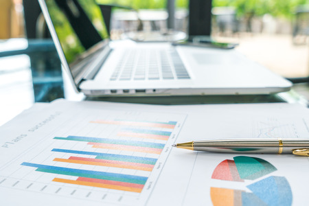 Financial charts on the table with laptopの写真素材