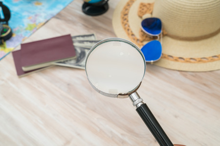 Travel preparation : compass, money, passport, road map ,hat,sunglasses,magnifying glass on wooden tableの写真素材