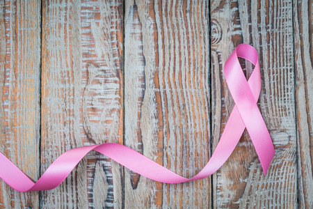 World cancer day : Breast Cancer Awareness Ribbon on wood Backgroundの写真素材