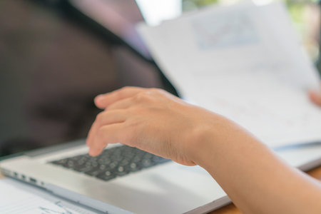 Business woman hand with Financial charts and laptop on the table
