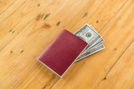 Blank passport with US dollars on wood tableの写真素材