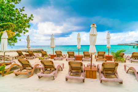 Beach chairs with umbrella at Maldives island, white sandy beach and seaの写真素材
