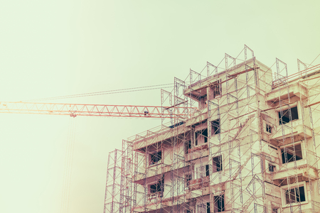 Crane and building construction site ( Filtered image processed vintage effect. )の写真素材