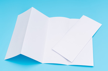 Four- fold white template paper on blue backgroundの写真素材