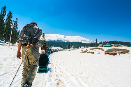 Sled driver carry the tourist on snow sled up to the hill,Kashmir state, India .の写真素材