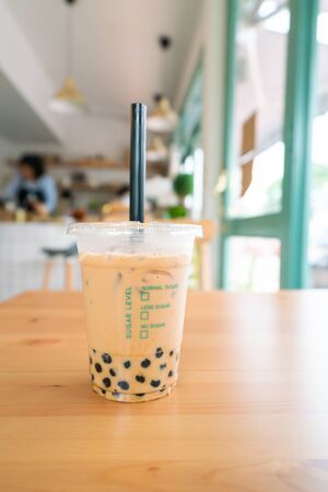 Milk Bubble Tea with Tapioca Pearls on wooden table.の写真素材