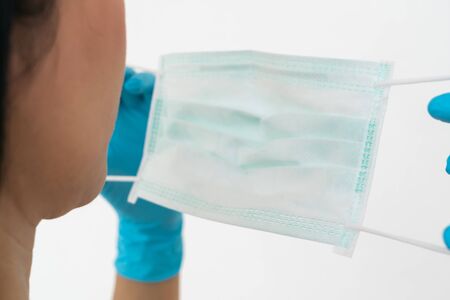 A woman wears a face mask that protects against the spread of Coronavirus (COVID-19). Surgical mask. Medical mask. Face mask.の写真素材