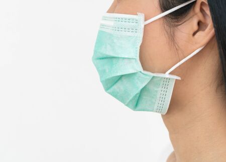 A woman wears a face mask that protects against the spread of Coronavirus (COVID-19). Surgical mask. Medical mask. Face mask.の写真素材
