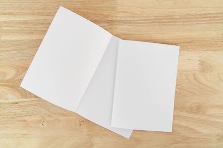 A4 half-fold brochure blank white template for mock up and presentation design on wooden surface.の写真素材