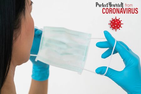 Surgical mask.  A woman wears a face mask that protects against the spread of Coronavirus (COVID-19).の写真素材