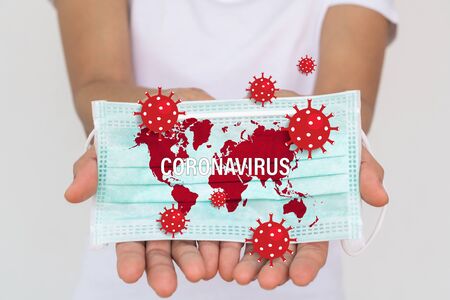 A woman holding a face mask. Surgical mask protects against the spread of Coronavirus (COVID-19).の写真素材