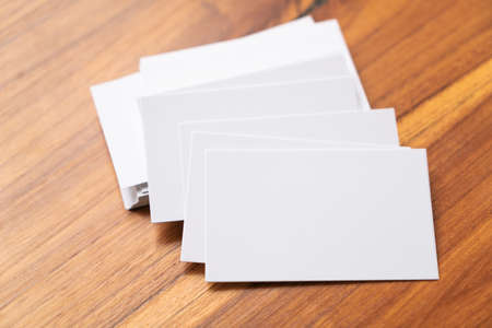 Blank mock up (business card) and cup of coffee on wooden background. Mock up for design.の写真素材