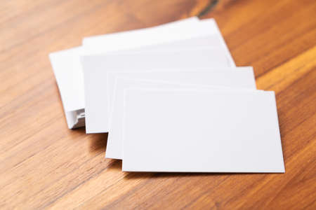 Blank mock up (business card) and cup of coffee on wooden background. Mock up for design.の写真素材