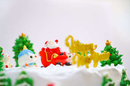 Christmas cake decorated with sweet figures of Christmas tree, Santa and sleigh.の写真素材