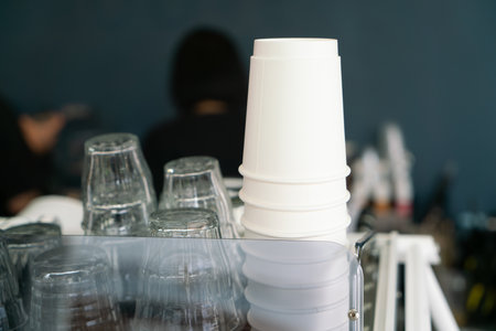 Drinking Glass cups and paper cups on the shelf.の写真素材